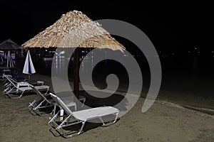 Beach chairs and umbrellas at night