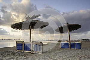 Beach chairs and umbrellas, on a Spanish beach, put away for the evening