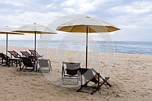 Beach chairs under a cream umbrella on the fine beach.