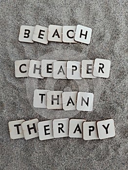 Beach cheaper than therapy message on wood blocks on sand at the beach