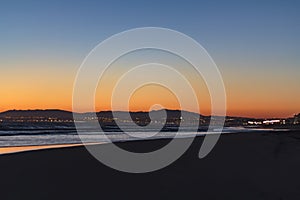 Beach and city lights at sunset