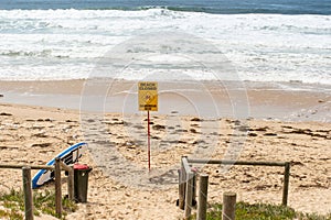 Beach closed sign and surf rescue board at the beach in Australia