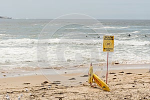 Beach closed sign and surf rescue board at the beach in Sydney