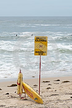 Beach closed sign and surf rescue board at the beach in Sydney