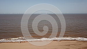 Beach ,coast line England ,off shore green wind power , windfarm ,green energy drone shot airal