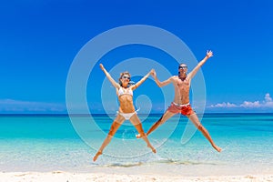 Beach couple looking. Happy young couple lying on sand under sun