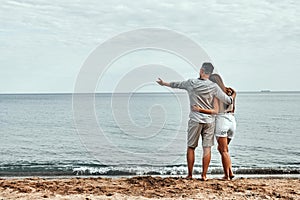 Beach couple walking on romantic travel honeymoon vacation summer holidays romance. Back view of casual happy lovers in full body