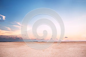 Beach on dusk with pink sand under blue sky