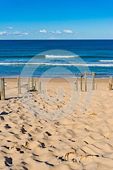 Beach entrance with sand and ocean on sunny day