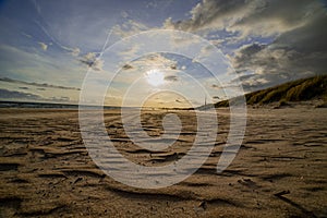Beach in the evening sun with dark clouds in the sky