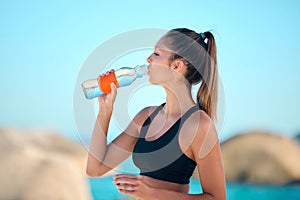 Beach, exercise and woman drinking water, health and training with stress relief, relax and break. Female person, girl