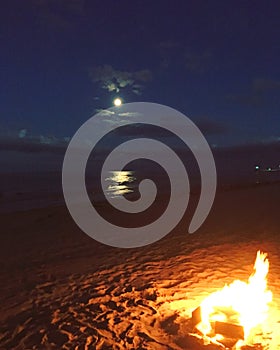 Beach fire under moonlight