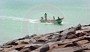 Beach with fishermen wooden motor boat.