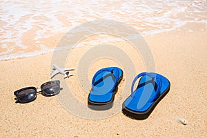 Beach, flip flop sandals, sunglasses and airplane. Holidays concept