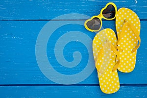 Beach flip-flops on blue wooden background