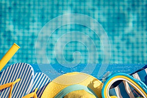 Beach flip-flops and snorkel mask on blue wood against swimming pool background