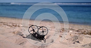 On the beach FPV drone lying on the sand, which lost its signal and fell down.