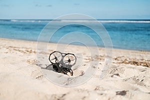 On the beach FPV drone lying on the sand, which lost its signal and fell down. photo