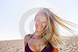 Beach freedom. Portrait of an attractive young blonde woman in a bikini relaxing at the beach.