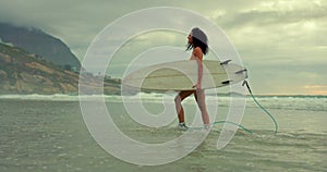 Beach, freedom in summer and woman walking with surfboard on sand by sea or ocean for travel. Smile, surfing and morning