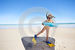 Beach, girl child and swimming inflatable, snorkel and excited for fun against ocean background. Adventure, portrait and