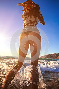 Beach girl stand in splashes in water