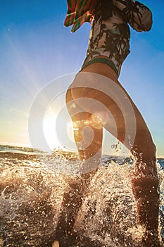 Beach girl stand in splashes in water