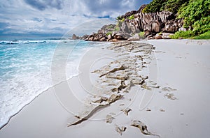 Beach Grand Anse on La Digue island, Seychelles. White sand and unique granite rock formation in background