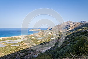 The beach by the greenhouses and olive trees in the countryside , in Europe, in Greece, in Crete, towards Kissamos, towards Chania