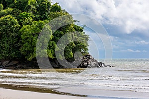 The beach has rocky outcrops in the sea.