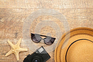 Beach hat with seashells and sand on broun background