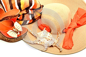 Beach hat, towel, stylish woman shoes and a seashell
