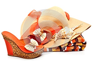 Beach hat, towel, woman shoes and a seashell