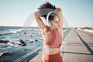 Beach, headphones and woman stretching for a fitness exercise, running or training for a race or marathon. Health