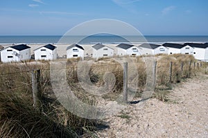 Beach holidays on sandy beach, waterfront wooden cottages in Katwijk-on-zee, North sea, Netherlands