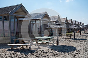 Beach holidays on sandy beach, waterfront wooden cottages in Katwijk-on-zee, North sea, Netherlands