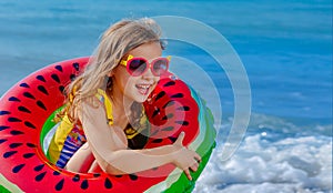 Beach holidays in summer on the seashore. A child with an inflatable ring. Safe rest on the water.