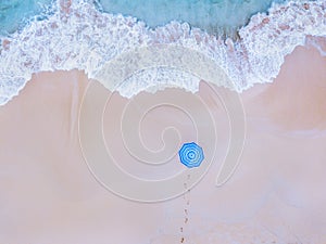 Beach holidays, vacation getaway on paradise island, aerial top down view of ocean wave and person with blue umbrella