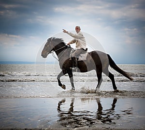 Beach horse rider pointing