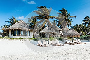 Beach houses and palms on the shores of the Caribbean Sea in Tulum, Mexico.