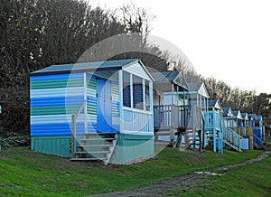 Beach huts chalets sheds in a row by the coast