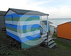 Beach huts chalets sheds in a row by the coast