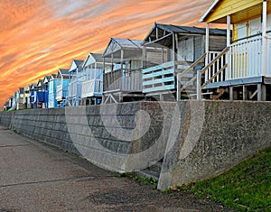 Beach huts chalets sheds in a row by the coast