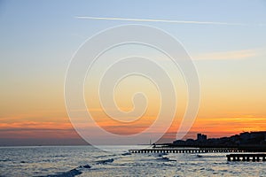 Beach landscape at dawn. Piers perspective view with people. Jesolo beach view