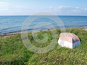 Beach landscape -Skiff boat on the grass photo