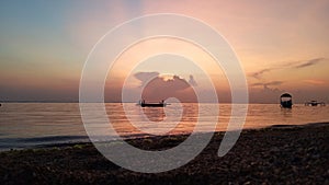 Early morning glow with romantic sunrise sky color scenery over the sea. Sanur Beach, Bali, Indonesia