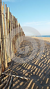 Beach landscape with a wood fence shadows