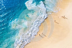 Beach and large ocean waves. Coast as a background from top view. Blue water background from drone. Summer seascape from air.