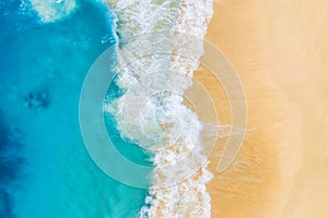 Beach and large ocean waves. Coast as a background from top view. Blue water background from drone. Summer seascape from air.