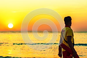 A beach lifeguard dressed in yellow - red uniform at the seasise during sunset in a beach of Dubai in the United Arab Emirates